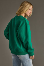 Person wearing a green sweatshirt against a gray background
