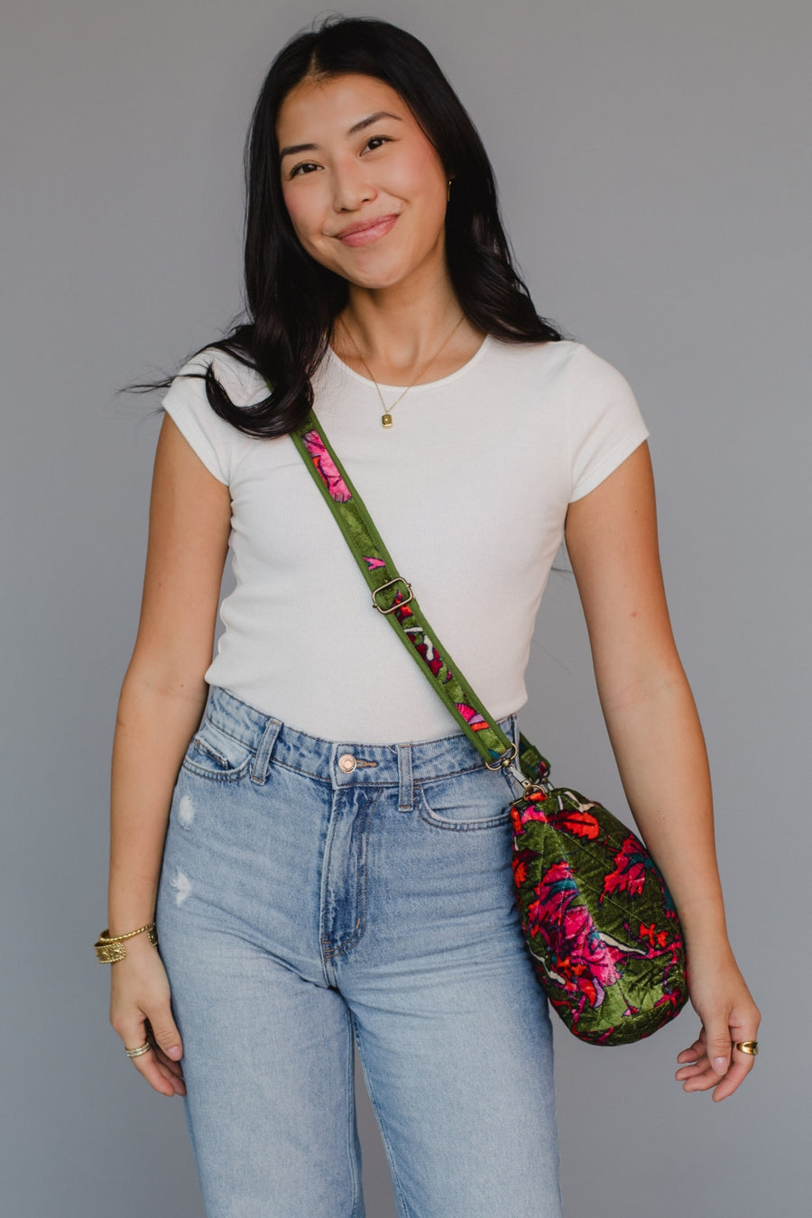 Woman holding a floral bag against a gray background