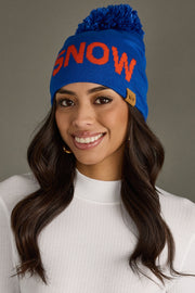 Woman wearing a blue 'SNOW' beanie with a gray background