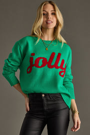Woman wearing a green sweater with 'jolly' in red text against a gray background