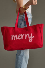 Red tote bag with 'merry' text held by a person wearing jeans and a white shirt.