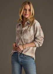 A woman with long blonde hair wears the Lia Super Soft Button Up by panacheaccessories and blue jeans, standing against a plain gray background and looking to the side with a slight smile.