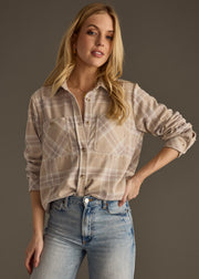 A woman with long blonde hair poses against a plain background, wearing the panacheaccessories Hilarie Super Soft Button Up and light blue jeans, with one hand on her hip.