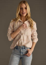 A young woman with long blonde hair models the Blaire Super Soft Button Up by panacheaccessories and light blue jeans, standing against a plain gray background with one hand in her pocket and a relaxed expression.