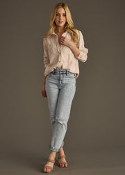 A woman with long blonde hair wears the Blaire Super Soft Button Up from panacheaccessories, paired with light blue ripped jeans and strappy sandals, standing against a plain dark background.