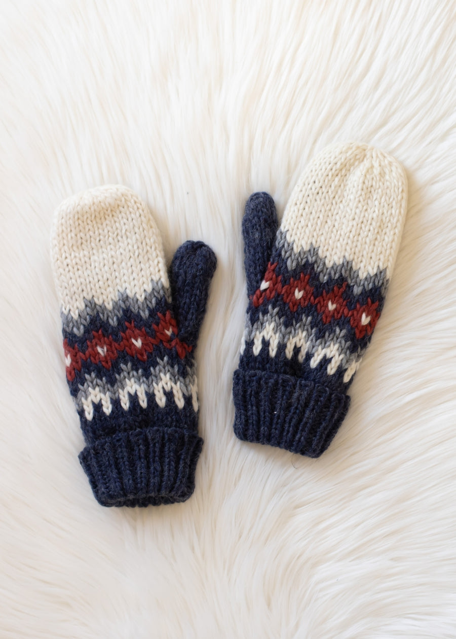 Pair of knit mittens with a pattern on a white textured background