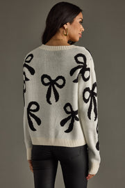 Woman wearing a sweater with black bow patterns on a gray background