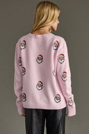 Pink sweater with Santa Claus patterns worn by a person on a gray background