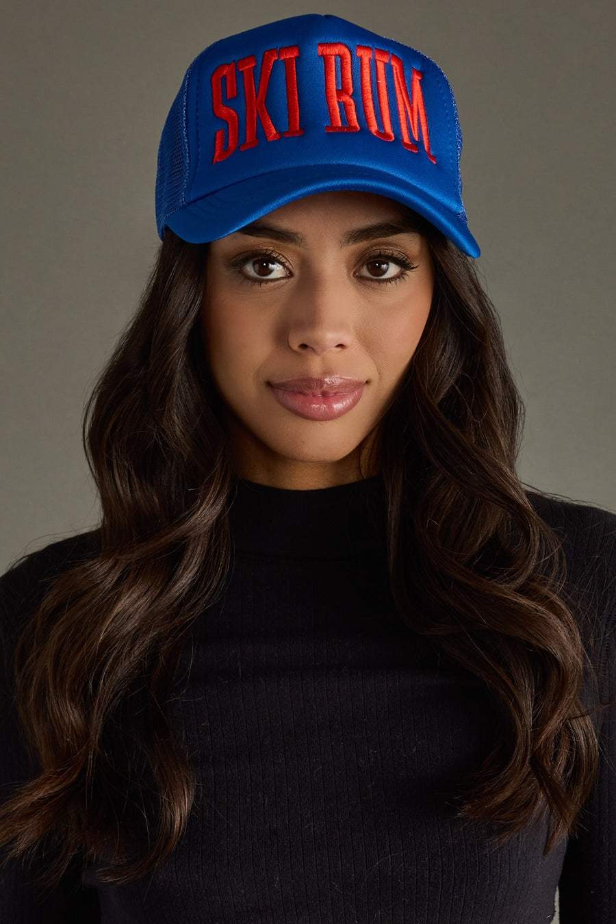 Woman wearing a blue cap with red text against a gray background