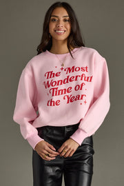 Person wearing a pink sweatshirt with red text on a gray background