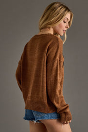 A cozy camel-brown knit sweater featuring bold black “Whiskey Weather” lettering across the front for a playful, seasonal statement. Designed with a relaxed fit, soft textured knit, and a classic crew neckline, this sweater offers all-day comfort with an effortlessly casual feel. Finished with long sleeves and ribbed cuffs and hem, it’s perfect for layering through cool fall days and pairing with your favorite denim.