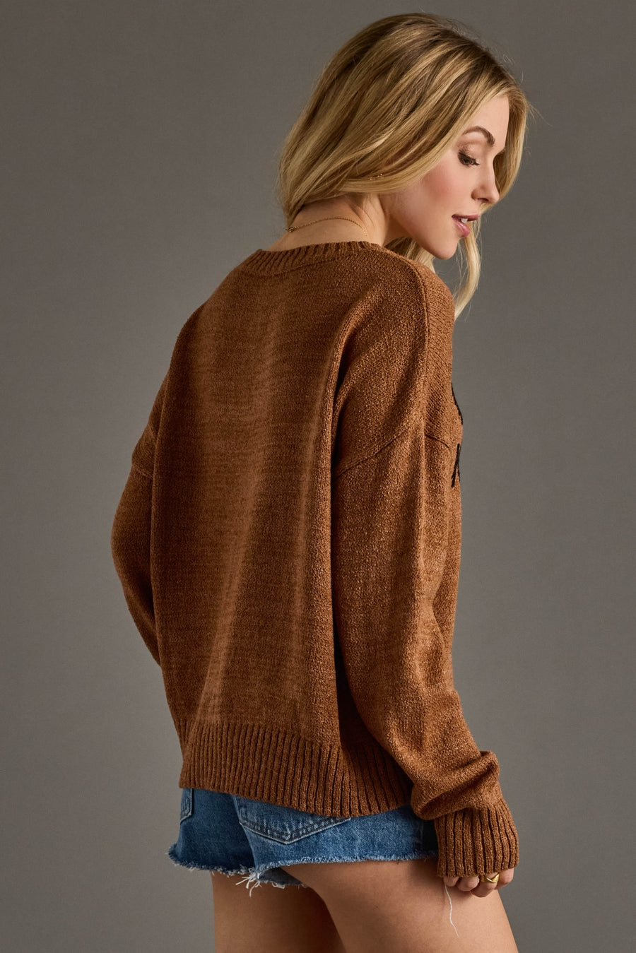 A cozy camel-brown knit sweater featuring bold black “Whiskey Weather” lettering across the front for a playful, seasonal statement. Designed with a relaxed fit, soft textured knit, and a classic crew neckline, this sweater offers all-day comfort with an effortlessly casual feel. Finished with long sleeves and ribbed cuffs and hem, it’s perfect for layering through cool fall days and pairing with your favorite denim.