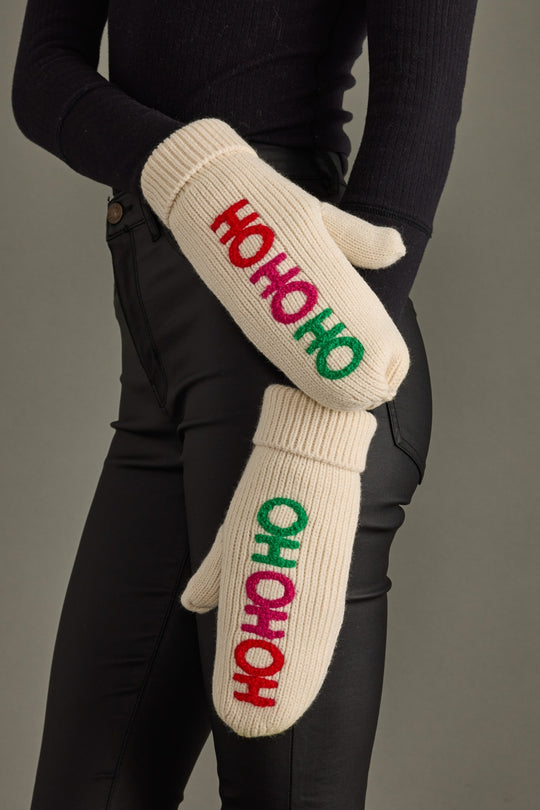 Beige mittens with 'HO HO HO' text in red, green, and pink on a gray background