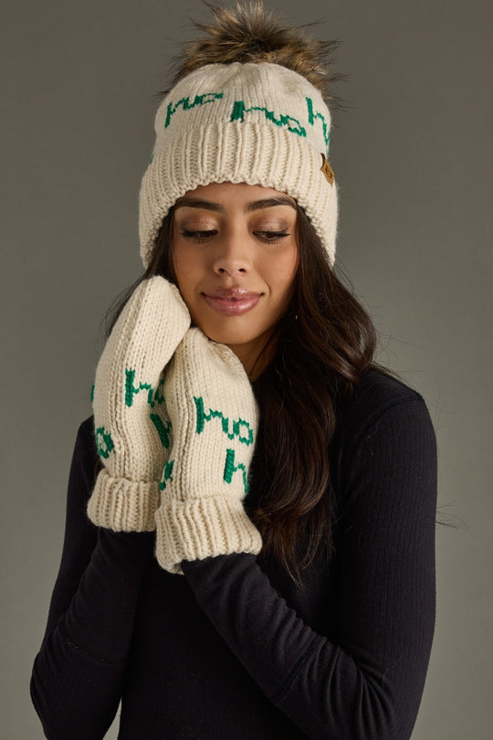 Woman wearing a cream knit hat and gloves with green text on a gray background