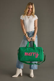 Woman holding a green bag with 'merry' written on it against a gray background