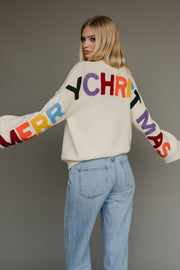 Ivory knit sweater with multicolored 'Merry Christmas' text on the back
