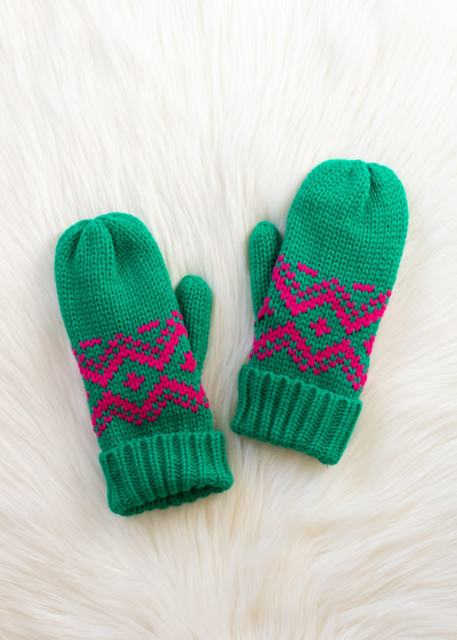Pair of green mittens with pink patterns on a white textured background