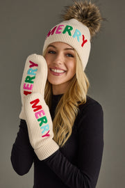 Person wearing a 'Merry' themed beanie and mittens on a gray background