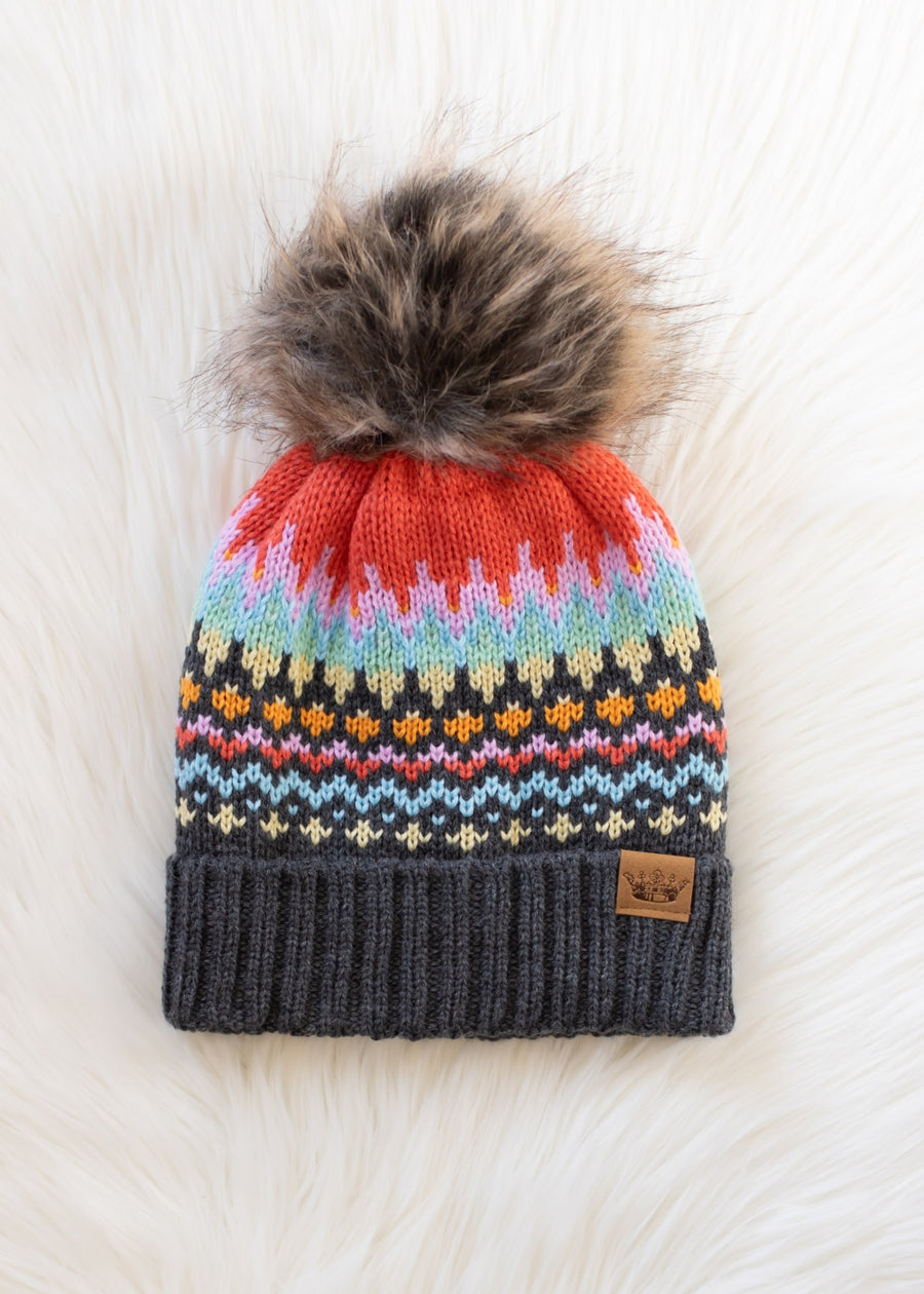 Colorful knit beanie with a fur pom-pom on a white background