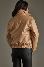 Person wearing a beige jacket against a gray background