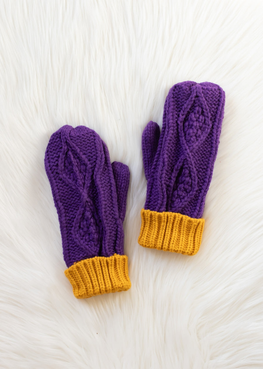 Pair of purple knit gloves with yellow cuffs on a white textured background