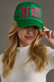 Person wearing a green cap with pink text on a gray background