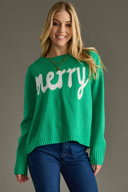 Woman wearing a green sweater with 'merry' text on a gray background