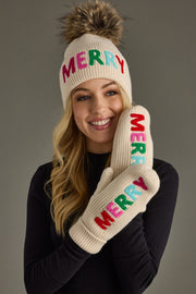 Person wearing a cream beanie and mittens with 'MERRY' in colorful letters on a gray background