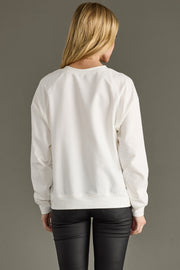 Person wearing a white sweatshirt with a plain background