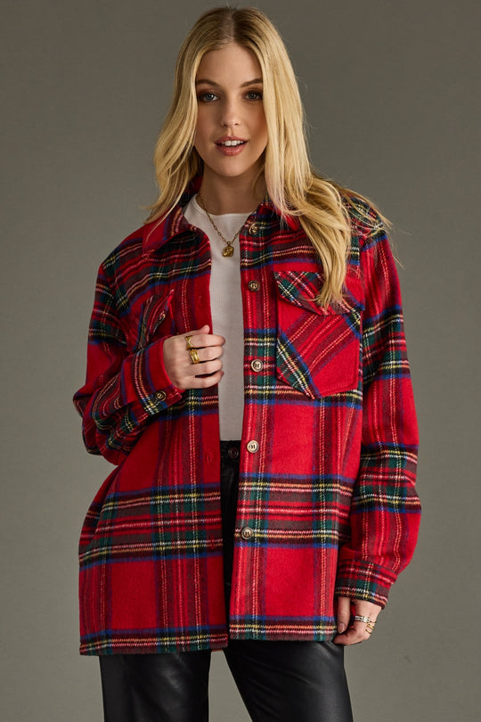 Woman wearing a red plaid jacket against a gray background