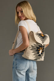 Woman wearing a backpack with a geometric pattern on a gray background