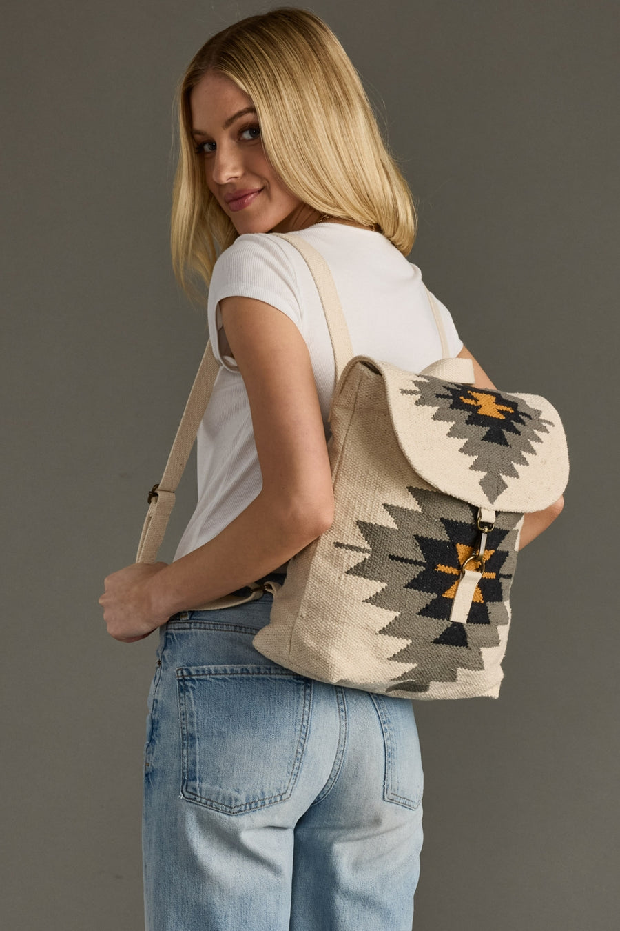 Woman wearing a backpack with a geometric pattern on a gray background