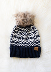 Knit hat with a pattern and pom-pom on a white background