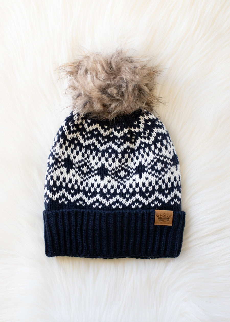 Knit hat with a pattern and pom-pom on a white background