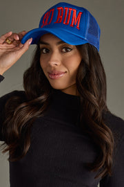 Woman wearing a blue cap with red text against a neutral background