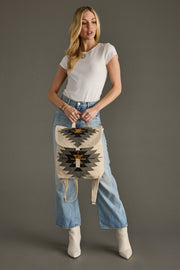 Woman holding a patterned bag against a gray background