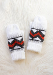 Pair of white knit mittens with black and red pattern on a textured white background