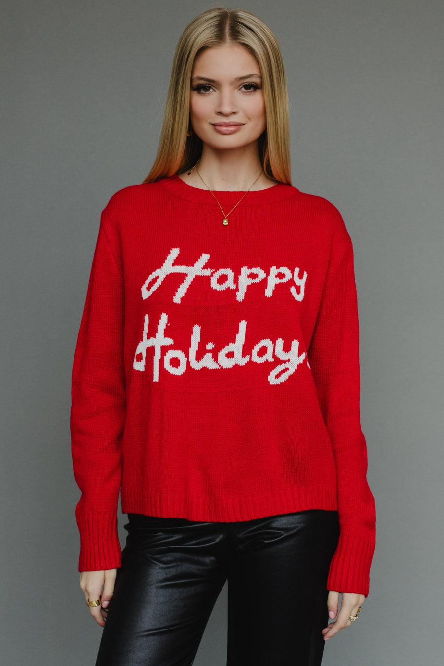 Woman wearing a red sweater with 'Happy Holiday' text on a gray background