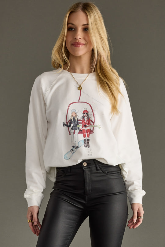 Woman wearing a white sweatshirt with graphic design on a gray background