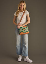 Woman holding a patterned bag against a plain background