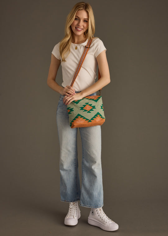 Woman holding a patterned bag against a plain background