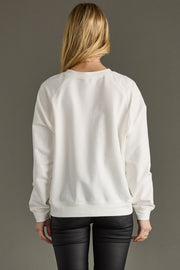 Person wearing a white sweatshirt with a plain background
