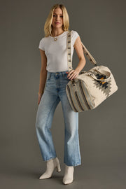 Woman holding a patterned bag against a gray background