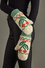 Knitted mittens with cherry pattern worn by a person against a neutral background