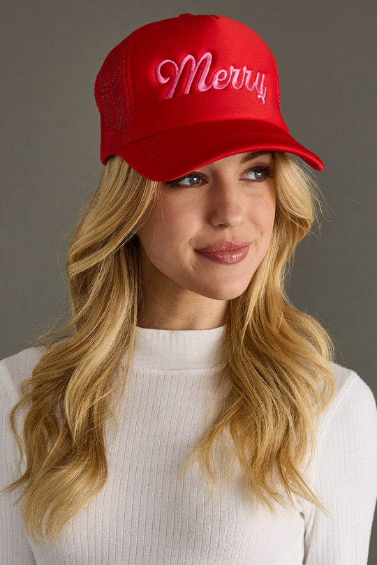 Woman wearing a red cap with 'Merry' text on a gray background