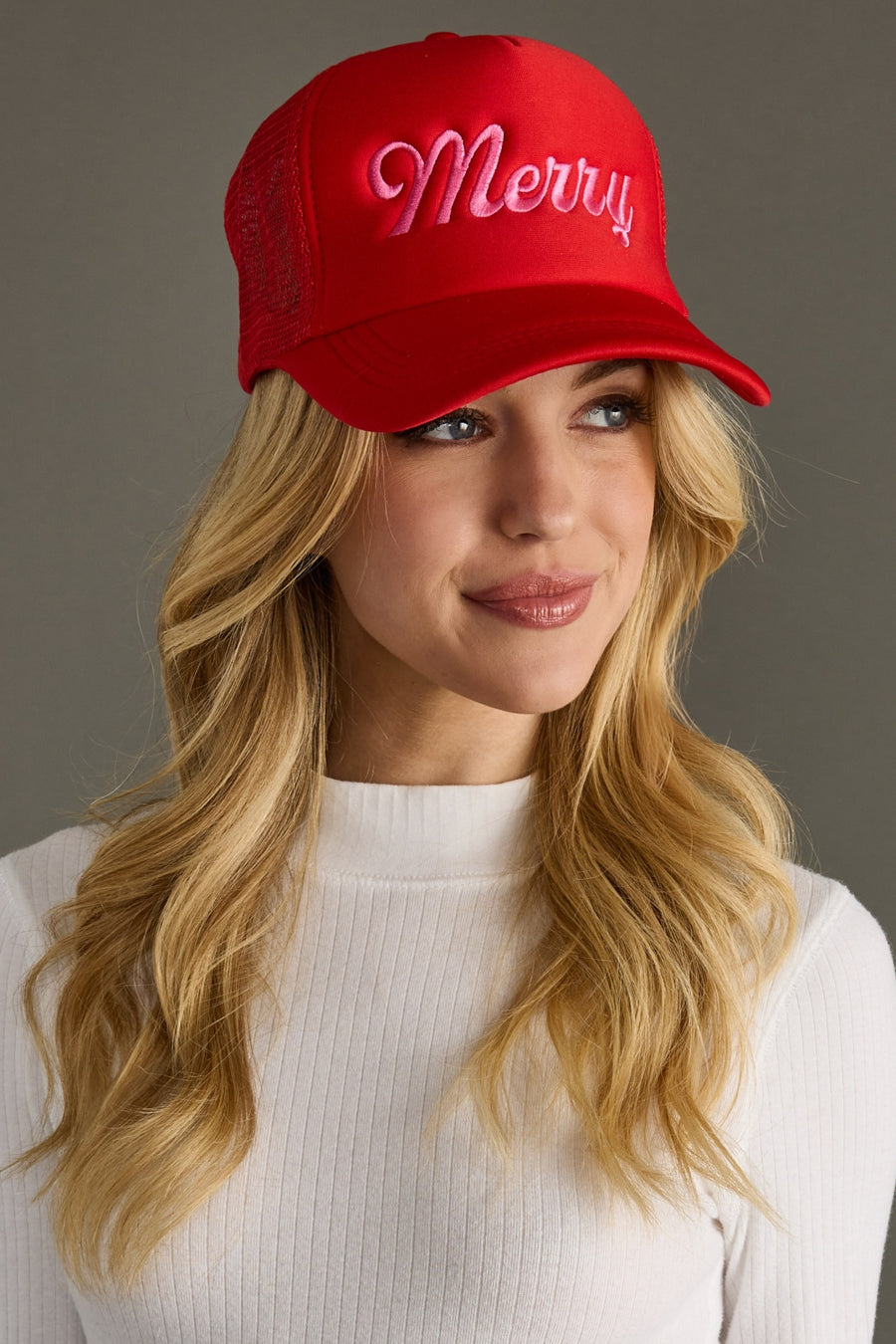 Woman wearing a red cap with 'Merry' text on a gray background