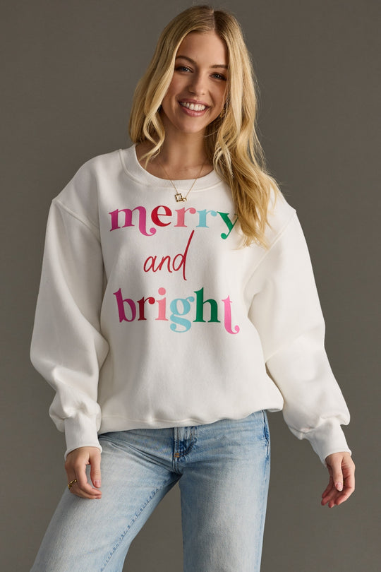 Woman wearing a white sweatshirt with colorful text on a gray background