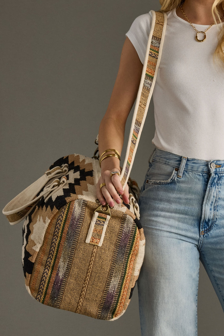 Person holding a patterned bag with a neutral background
