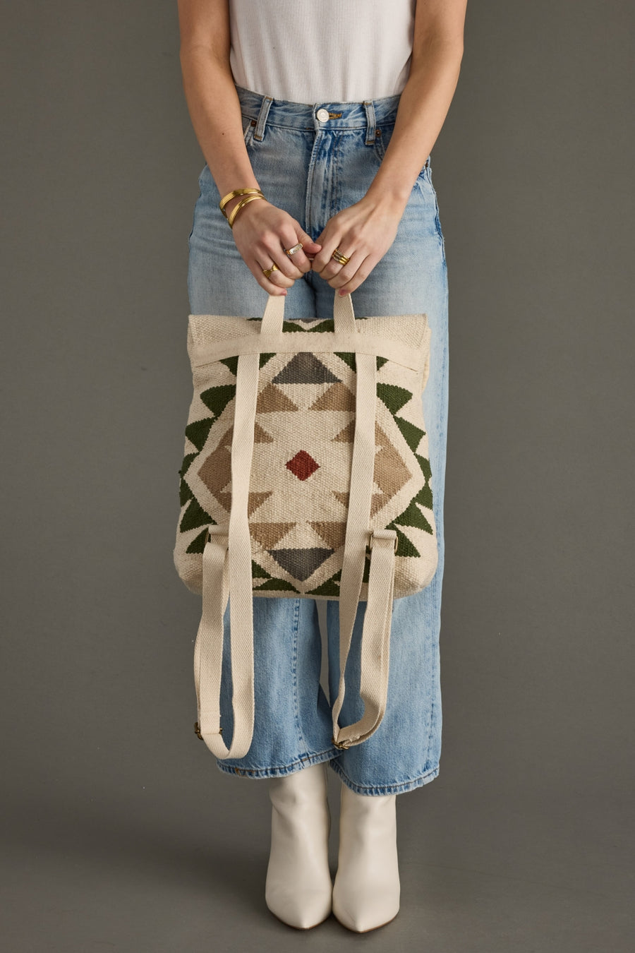 Person holding a patterned tote bag against a plain background