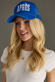 Woman wearing a blue cap with 'APRèS' text on a gray background